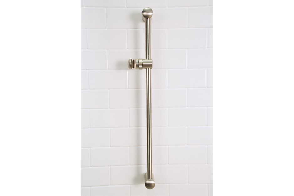 Brushed nickel shower bar installed on white tiled wall.