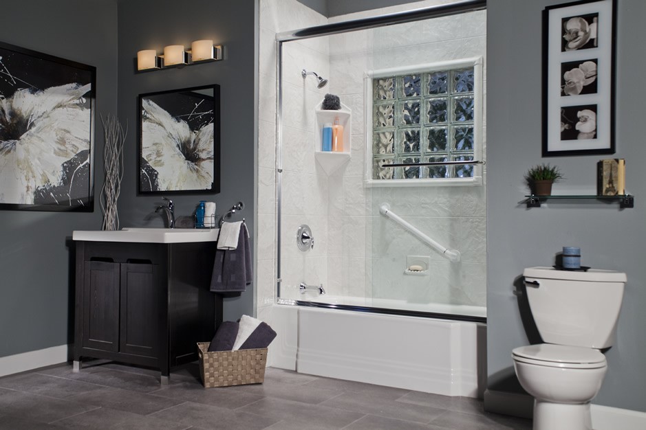 Bathroom with Accessible Features; gray walls, dark vanity with white countertop, tub-shower combination with a grab bar and glass block window.