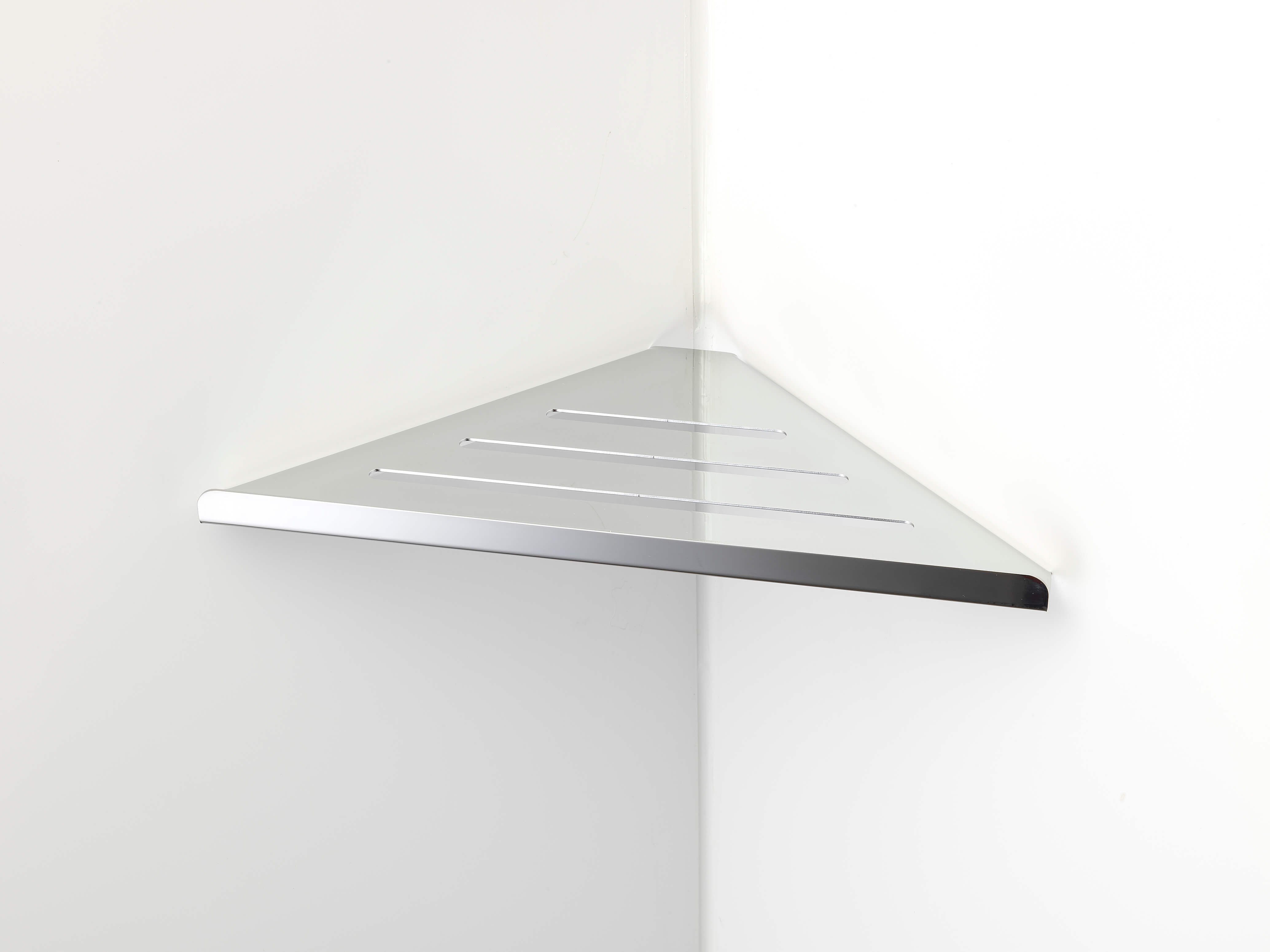 A metallic triangular corner shelf with slotted lines is mounted on a white wall in the corner of a room.