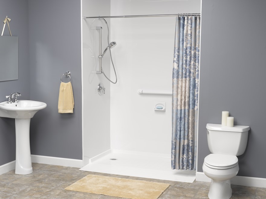 Bathroom with a walk-in shower, grab bar, pedestal sink, toilet, and tan bath mat.