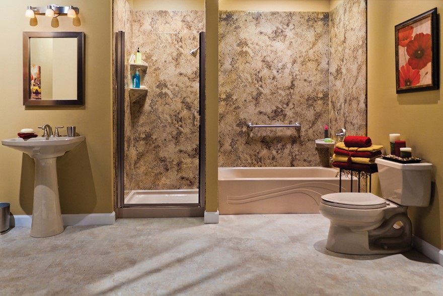 A bathroom with a pedestal sink, wall mirror, glass shower, bathtub with grab bar, toilet, stacked towels on a bench, and floral wall art on beige walls and tile flooring.