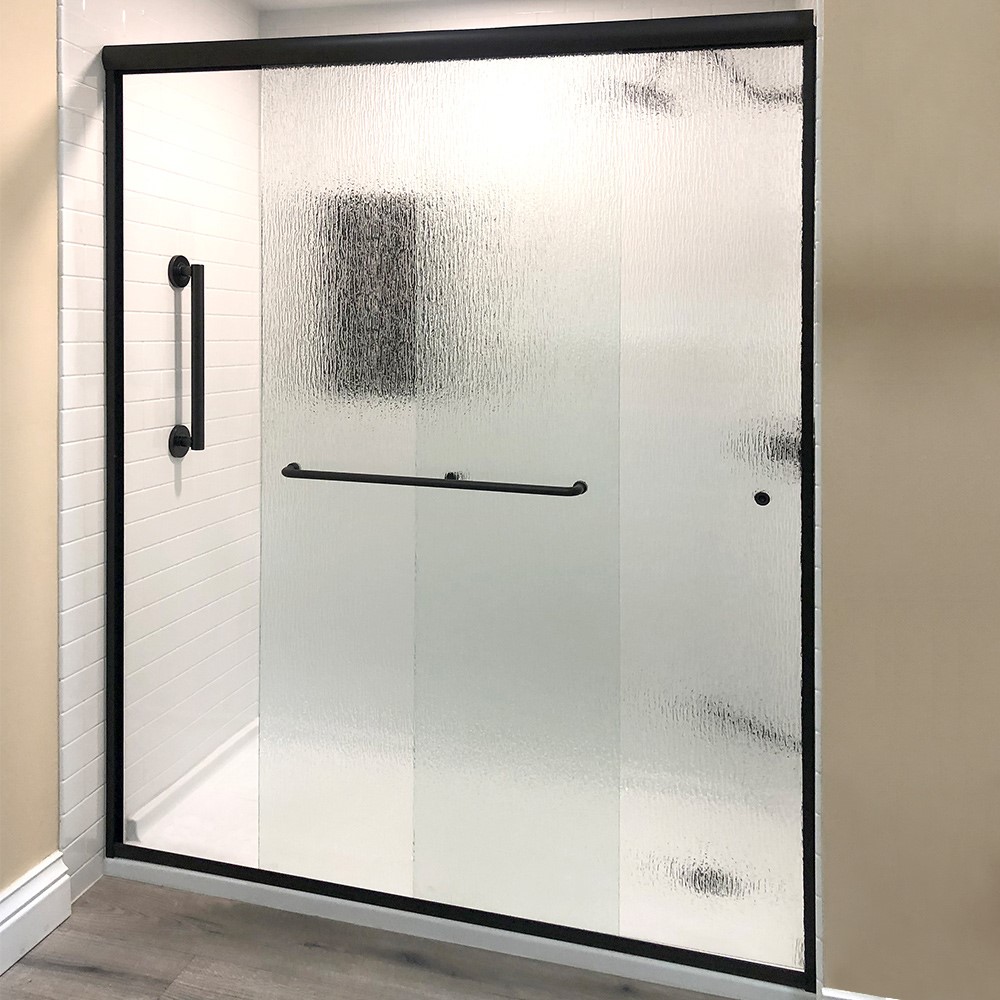 A modern shower with a sliding glass door featuring textured, frosted panels and black metal handles, set in a white-tiled shower stall with beige walls and gray flooring outside.