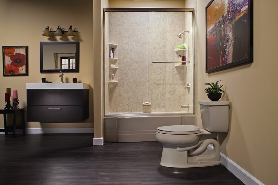 Bathroom with dark wood floors, an off-white toilet and tub with installed marble-esque shower, a dark wooden sink vanity, and beige walls.